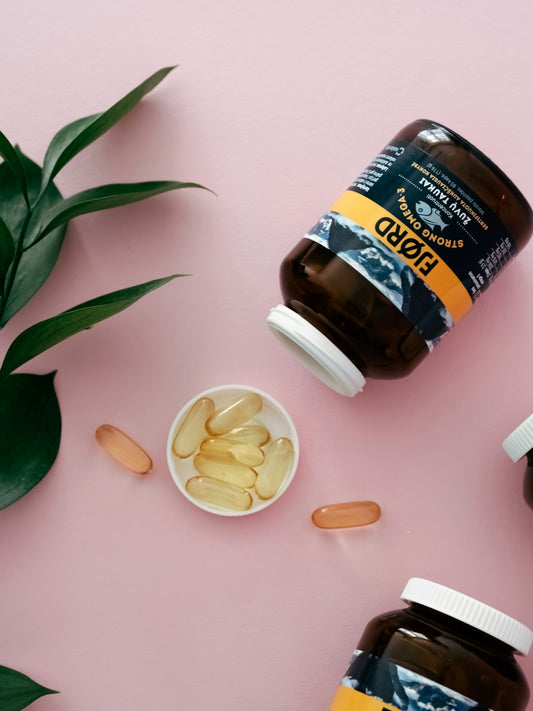Natural Immunity - three bottles of vitamins sitting on top of a pink surface
