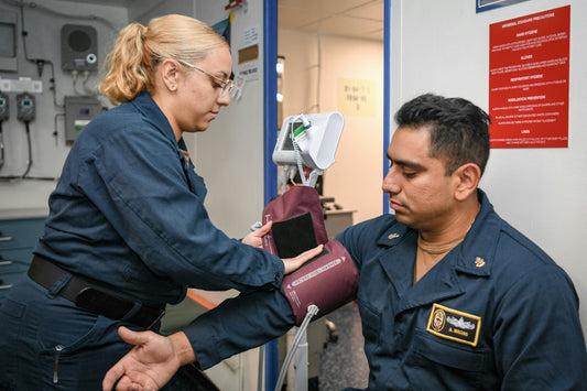Medical professional taking a sailor's blood pressure